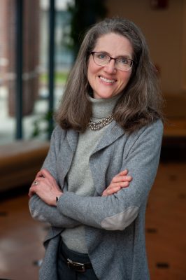 Shareen Hertel, Professor of Political Science and Human Rights, stands smiling with her arms crossed in The Dodd Center for Human Rights at UConn.