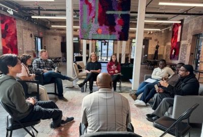 A small group in a circle is having a discussion during a Democracy and Dialogues workshop.