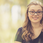 Sage Montana, a woman in a black shirt smiles at the camera.