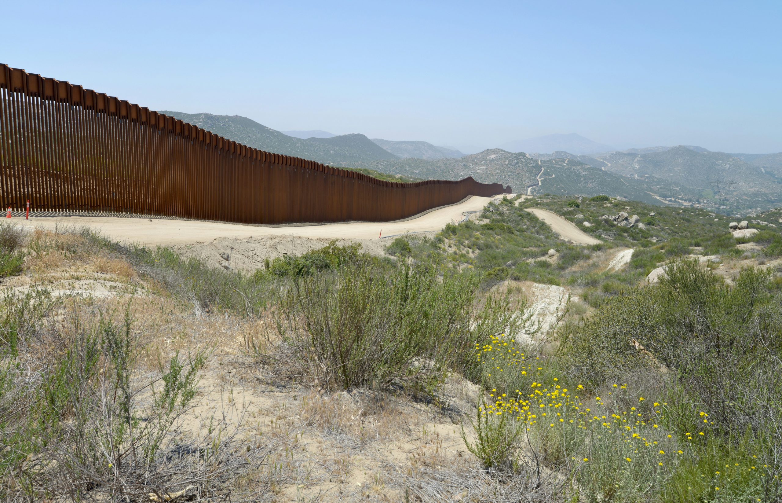 An indefinitely long fence in a desert terrain.